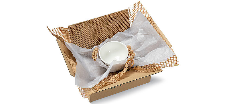 A box containing two bowls wrapped in brown and white paper padding.