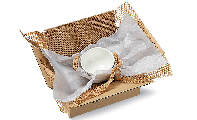 A box containing two bowls wrapped in brown and white paper padding.